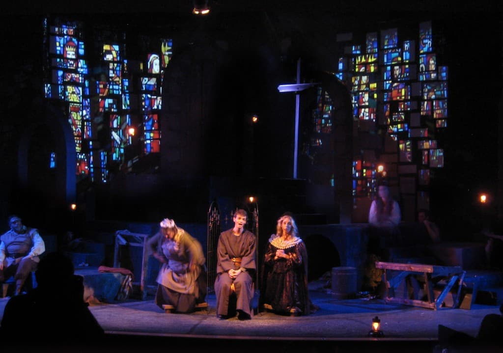 Man of La Mancha, Jean's Playhouse. Church windows are projected onto the stone bricks. A cross is erected from random sticks found in the dungeon.