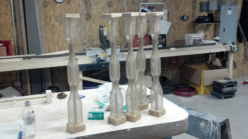 Photo of individual balustrade spindles being constructed on a table in the scene shop.