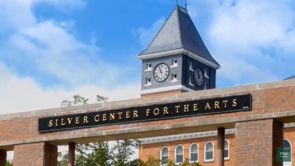 The Clock Tower of Rounds Hall visible above a walkway outside the Silver Center for the Arts at Plymouth State University